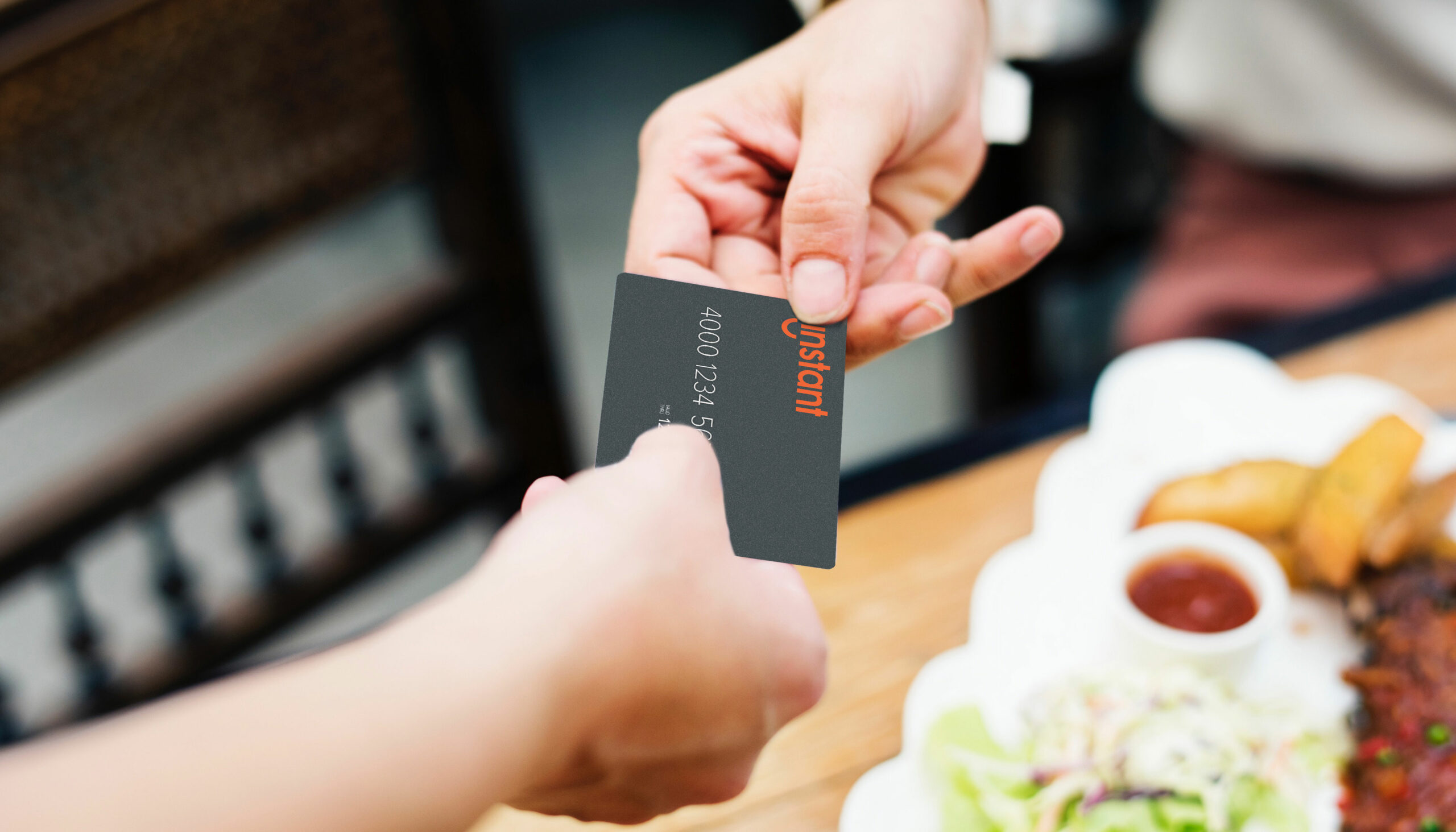 two hands holding instant pay card