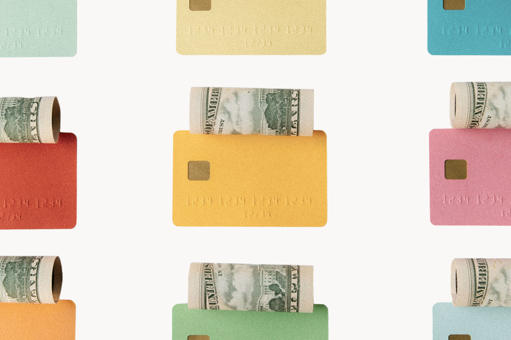 Colourful bank cards with rolled bills on top