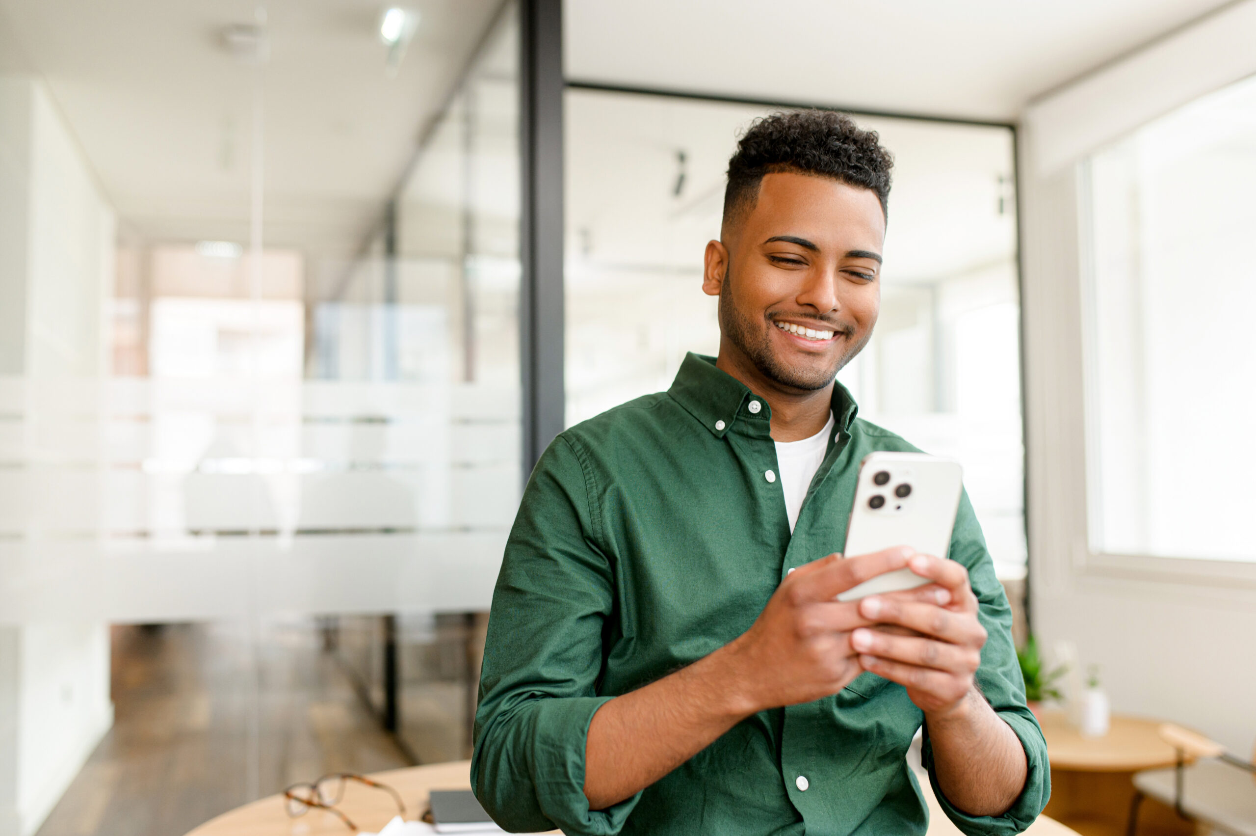 male employee using mobile phone to receive earned wage access payment after finishing work.