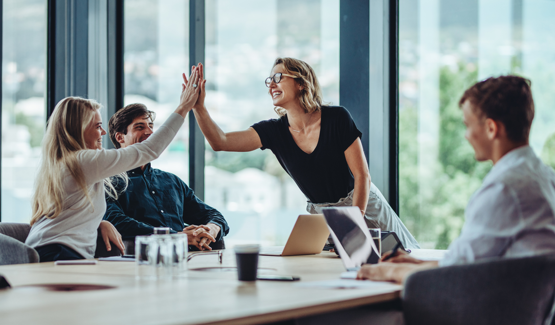 manager communicating the earned wage access (EWA) benefit with her employees and celebrating