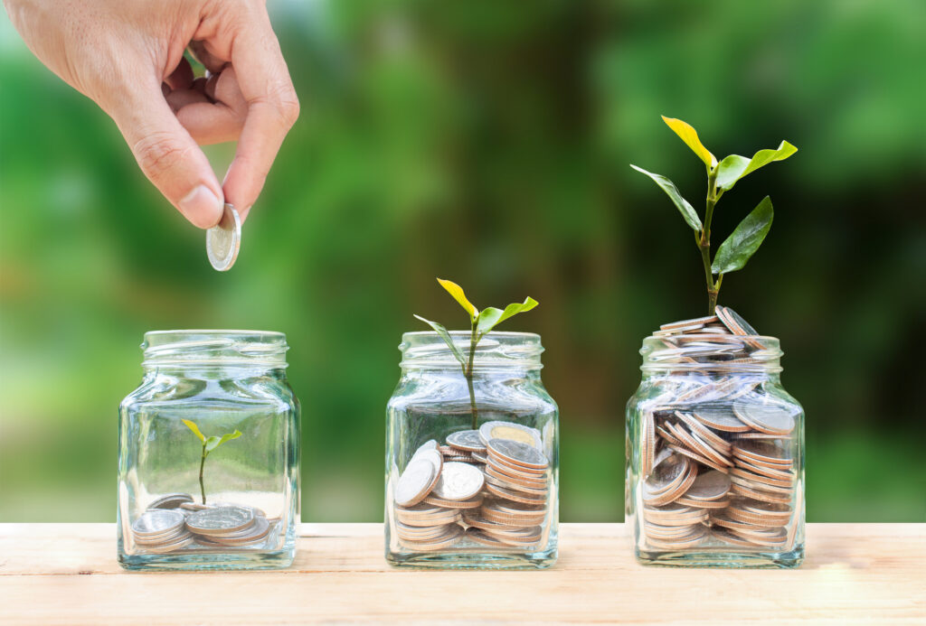 hand dropping coins into three jars