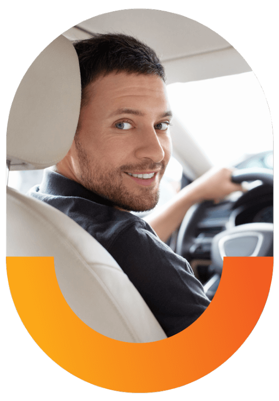 man driving car looking in backseat smiling