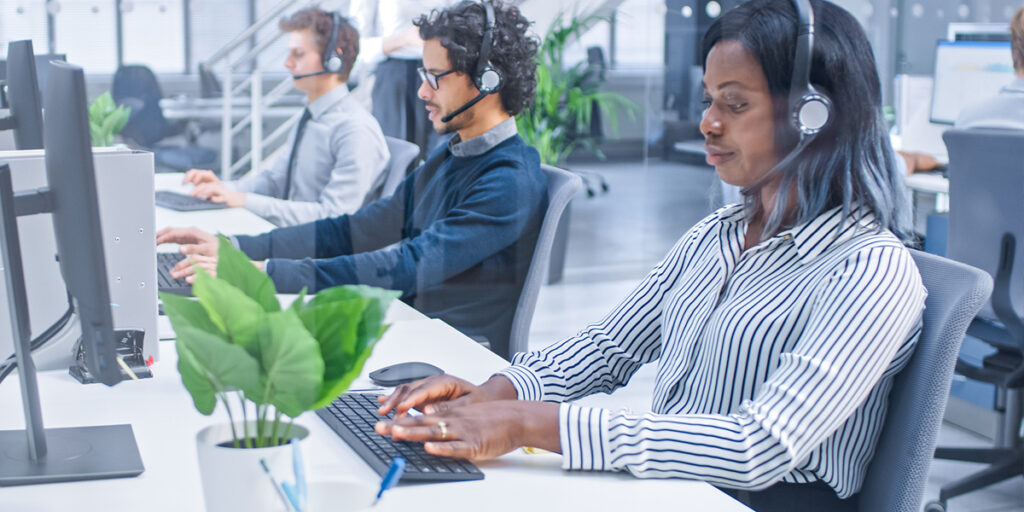 call center employees wearing headsets in modern office