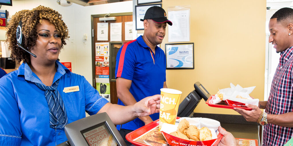 churchs chicken employees in store handing food to customers