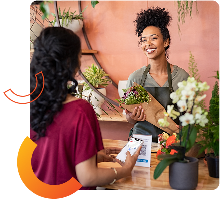 florist owners smiling at customer paying with instant card