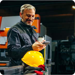 warehouse employee checking his phone and smiling