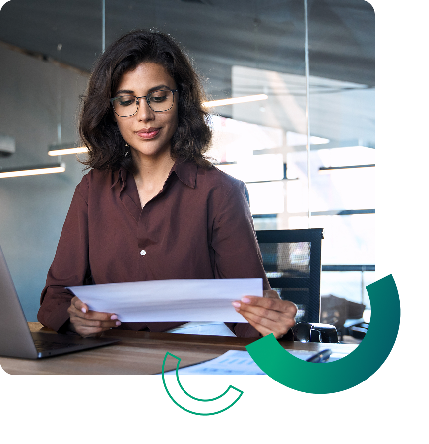 young professional woman reviewing paperwork at her desk