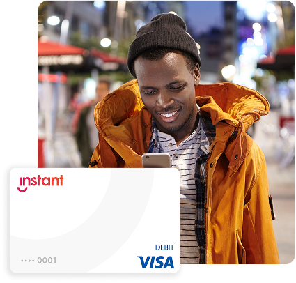 young happy male checking phone in coat and beanie outdoors